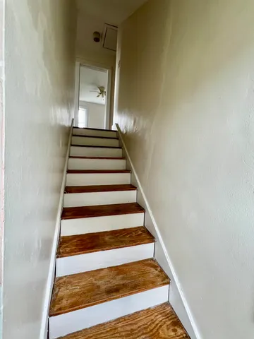 an empty room with wooden floor a ceiling fan and a window