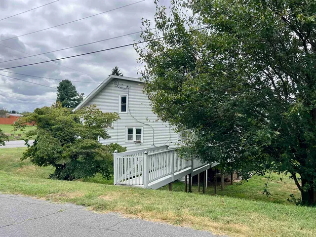 a view of a house with a yard and a porch