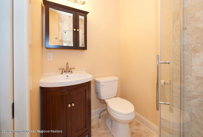 15 Spring Street Red Bank, NJ 07701 - Photo 18 of 30 a bathroom with a toilet a sink and mirror