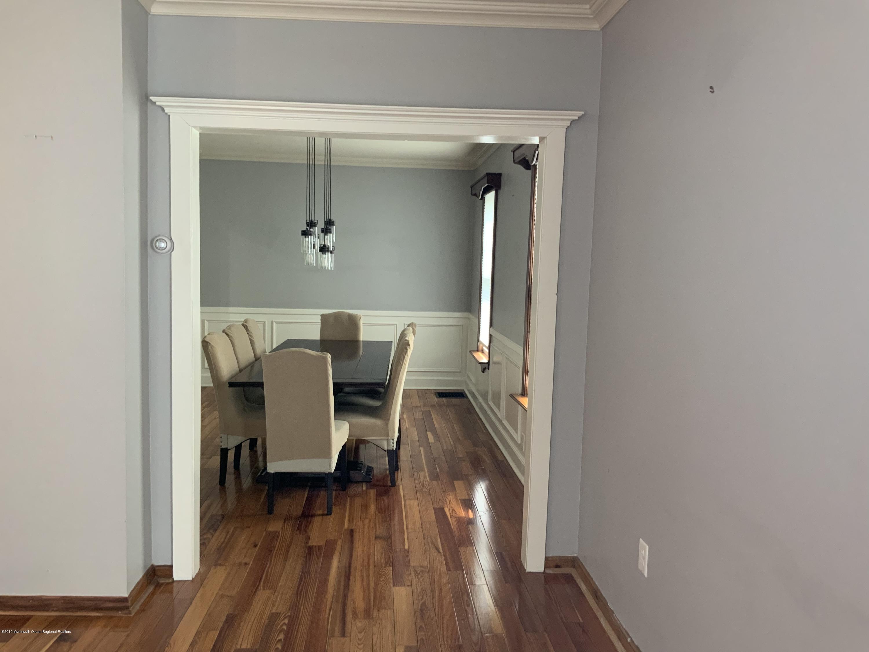 15 Spring Street Red Bank, NJ 07701 - Photo 6 of 30 a view of a hallway with wooden floor table and chairs
