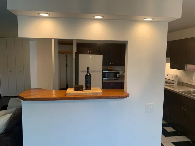 a kitchen with stainless steel appliances granite countertop a refrigerator and a stove