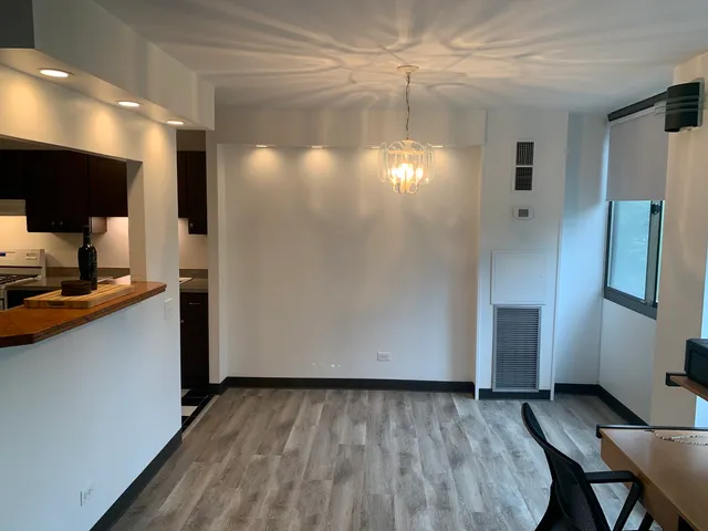 a view of a refrigerator in kitchen and an empty room