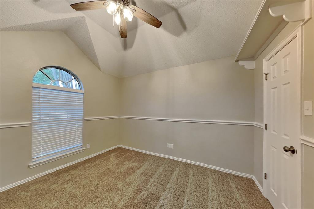 1526 Brittany Lane Mansfield, TX 76063 - Photo 12 of 18 Spare room with light colored carpet, a textured ceiling, ceiling fan, and vaulted ceiling