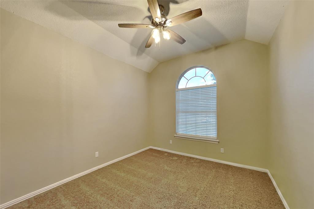 1526 Brittany Lane Mansfield, TX 76063 - Photo 13 of 18 Spare room featuring vaulted ceiling, carpet floors, a ceiling fan, and a textured ceiling