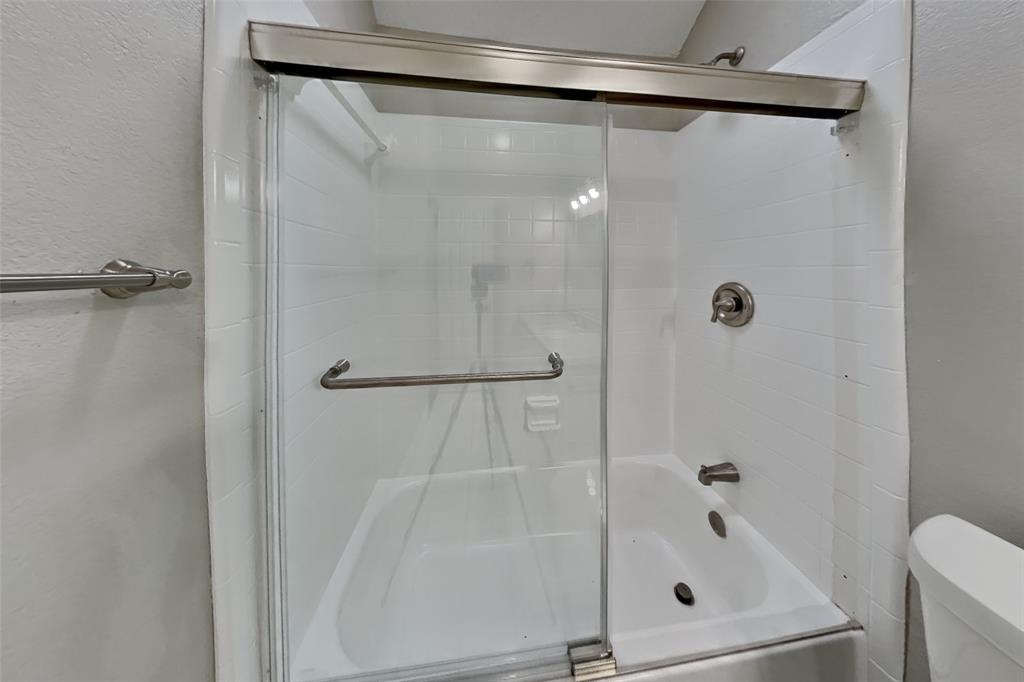 1526 Brittany Lane Mansfield, TX 76063 - Photo 15 of 18 Bathroom featuring a textured wall and enclosed tub / shower combo