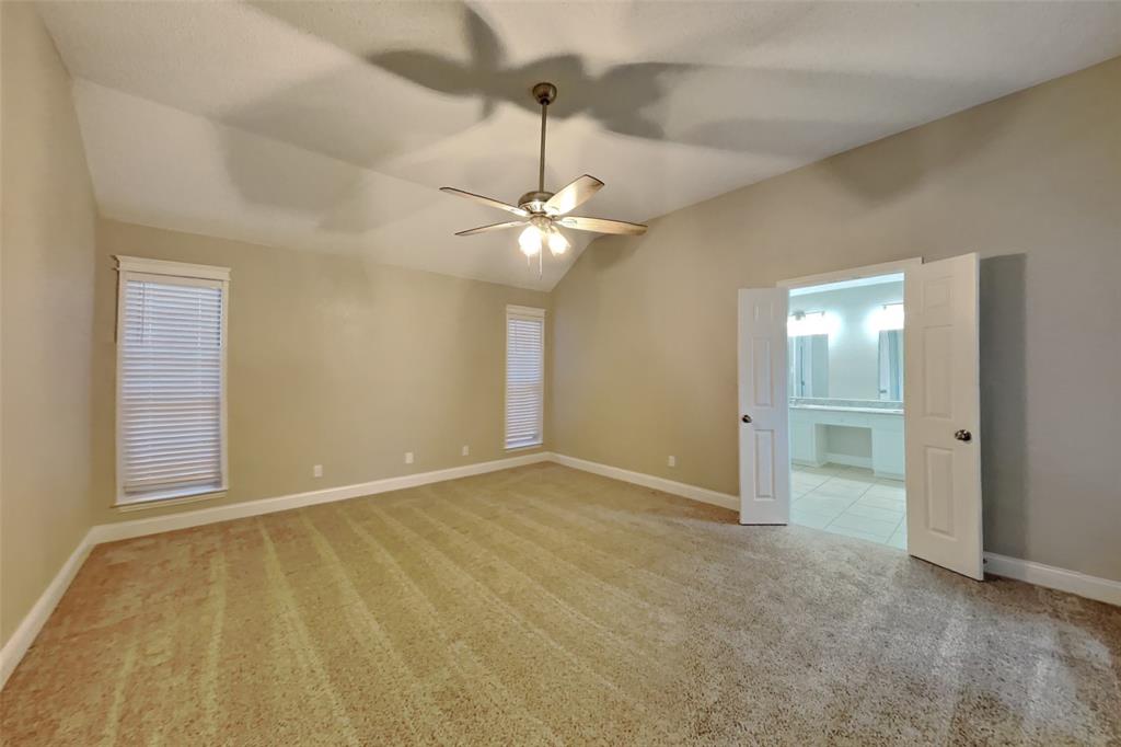 1526 Brittany Lane Mansfield, TX 76063 - Photo 7 of 18 Empty room featuring light colored carpet, vaulted ceiling, and ceiling fan