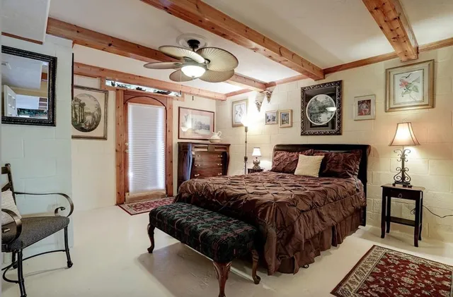 a bedroom with a bed a mirror and paintings on the wall