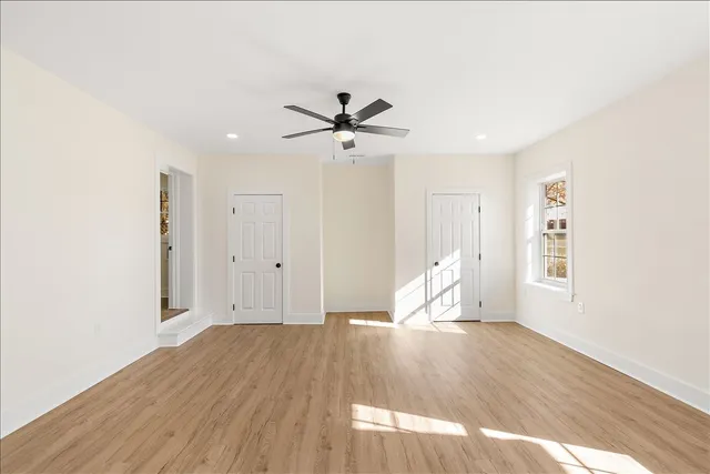 a view of a room with wooden floor and a ceiling fan