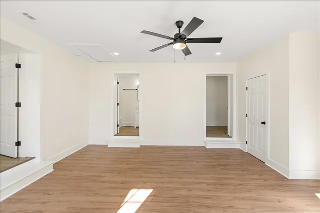 a view of a livingroom with a ceiling fan & wooden floor