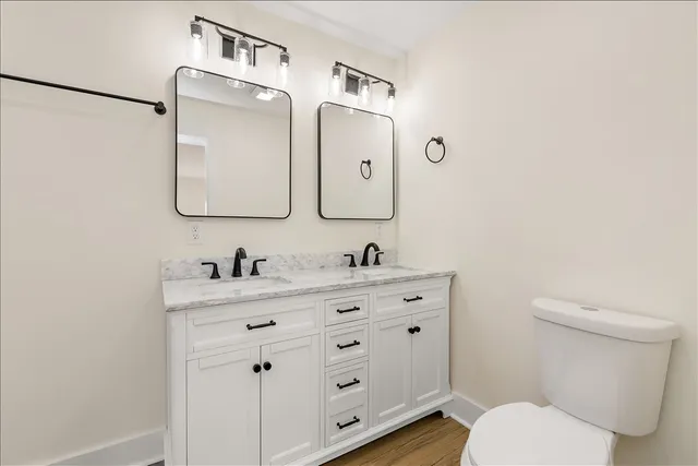 a bathroom with a granite countertop toilet sink and mirror
