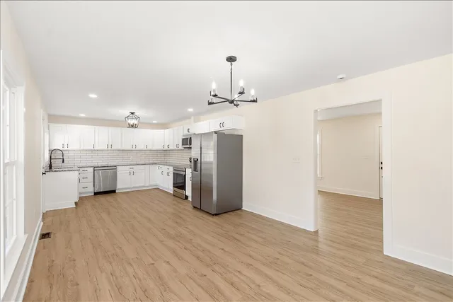 a view of a kitchen with a sink and wooden floor