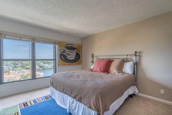 a bedroom with a bed and a large window