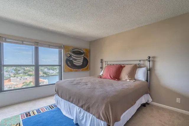 a bedroom with a bed and a large window