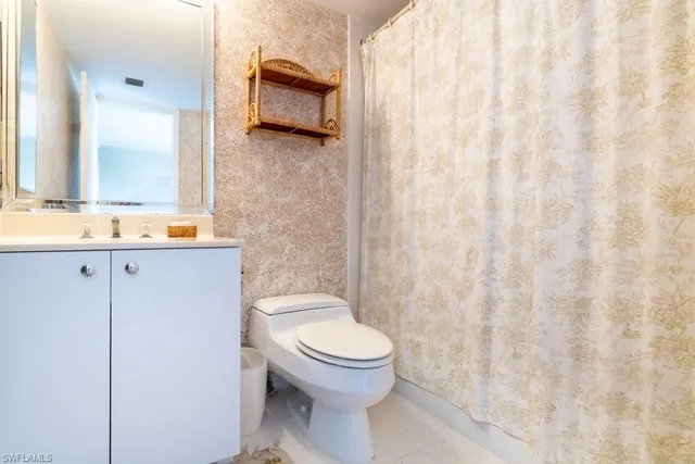 a bathroom with a toilet a sink and a mirror