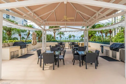 a view of a patio with a table and chairs under an umbrella