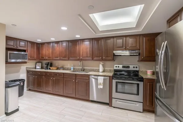 a kitchen with stainless steel appliances granite countertop a stove a sink dishwasher a refrigerator and a microwave oven