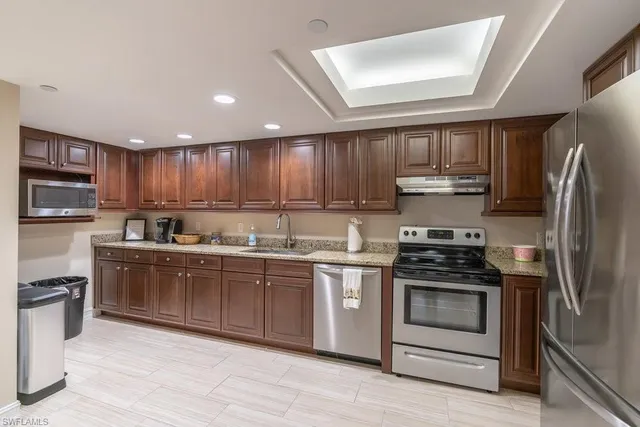 a kitchen with stainless steel appliances granite countertop a stove a sink dishwasher a refrigerator and a microwave oven