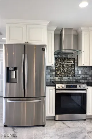 a kitchen with stainless steel appliances granite countertop a refrigerator and a stove top oven