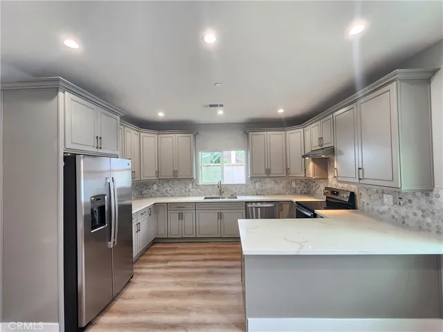 a open kitchen with kitchen island a sink stainless steel appliances and cabinets