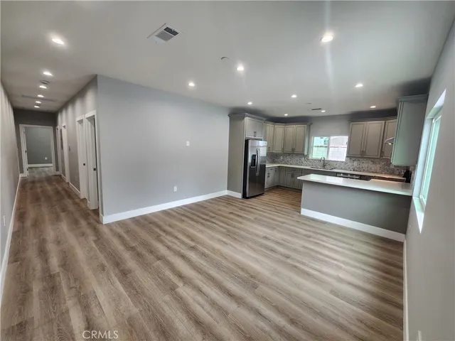 a kitchen with granite countertop white cabinets and stainless steel appliances
