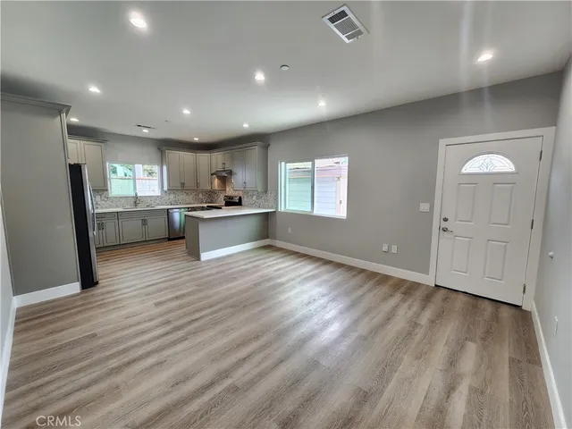 a view of a kitchen with wooden cabinet and a refrigerator