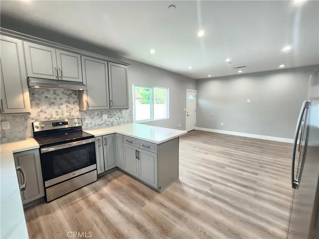an empty room with wooden floor and entrance