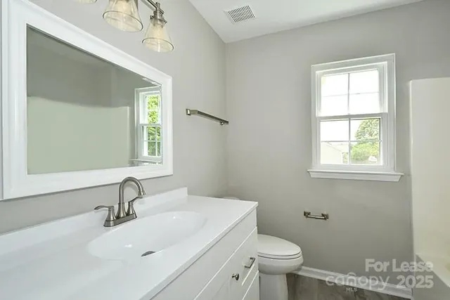 a bathroom with a sink a toilet and a mirror