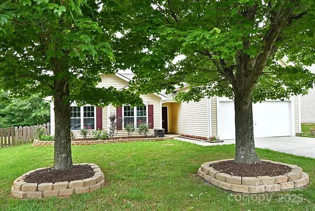 a front view of a house with a yard porch and a tree