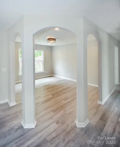 a view of empty room with wooden floor
