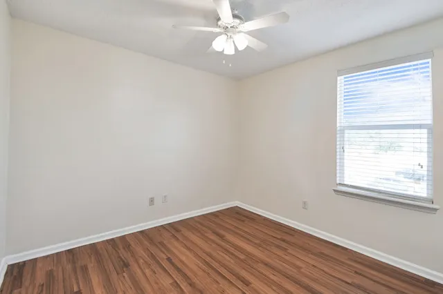 a view of an empty room with wooden floor