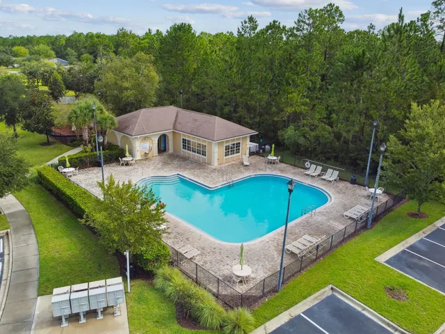 an aerial view of a swimming pool playground and residential houses with outdoor space