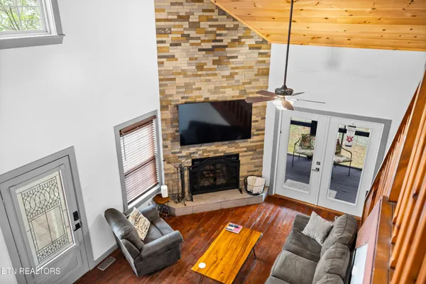 a kitchen with stainless steel appliances granite countertop a stove top oven a refrigerator a dining table and chairs with wooden floor