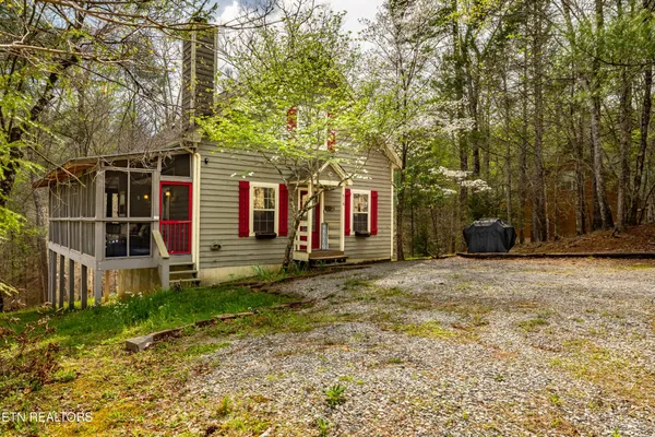 a view of a house with a yard and large tree