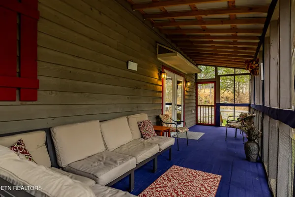 a view of a porch with furniture and wooden floor