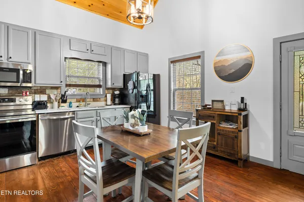 a kitchen with a table chairs refrigerator and microwave