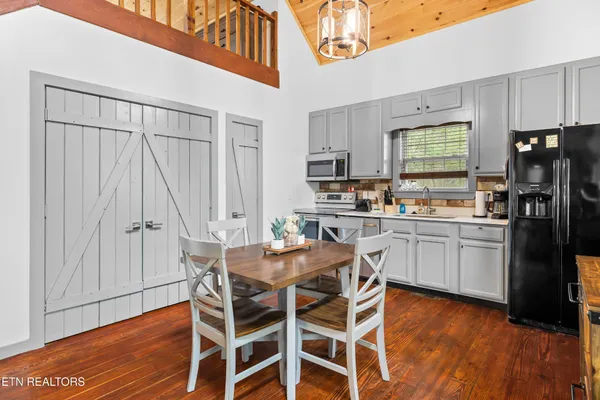 a kitchen with stainless steel appliances white cabinets and a window