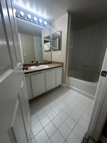 a bathroom with a toilet sink vanity granite and mirror