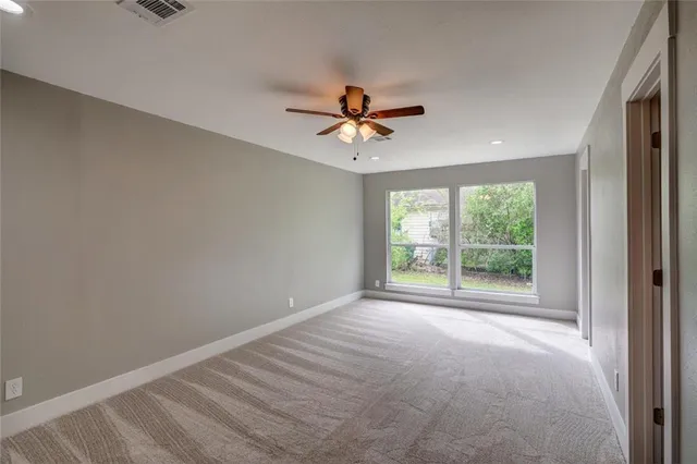 a view of a livingroom with a ceiling fan and window