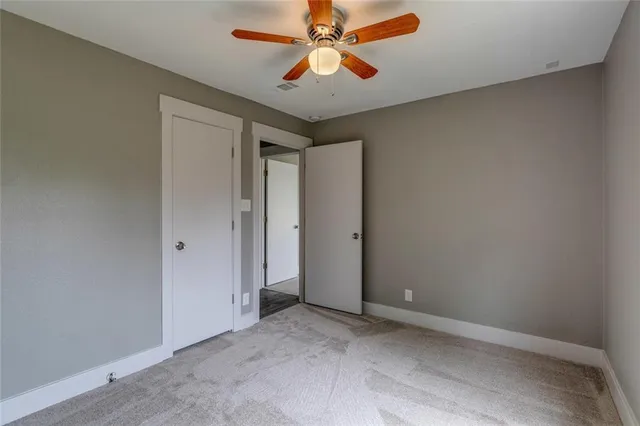 an empty room with chandelier fan