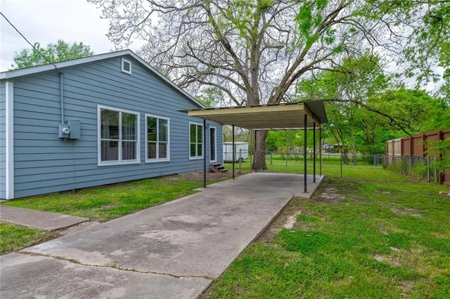 a view of a house with backyard and a tree