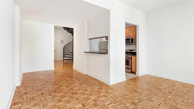 a view of a kitchen with wooden floor and a refrigerator