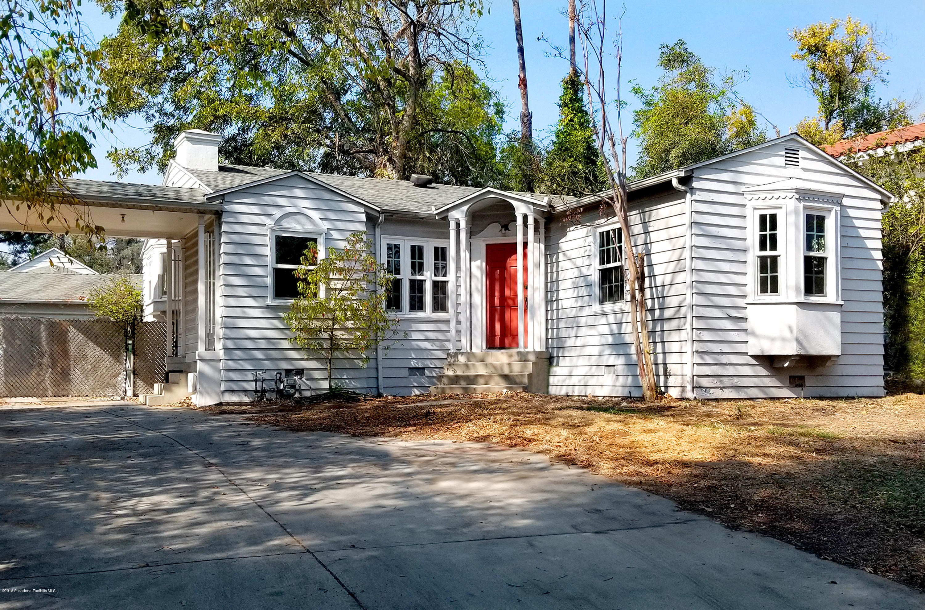 a view of a white house with large windows and a small yard