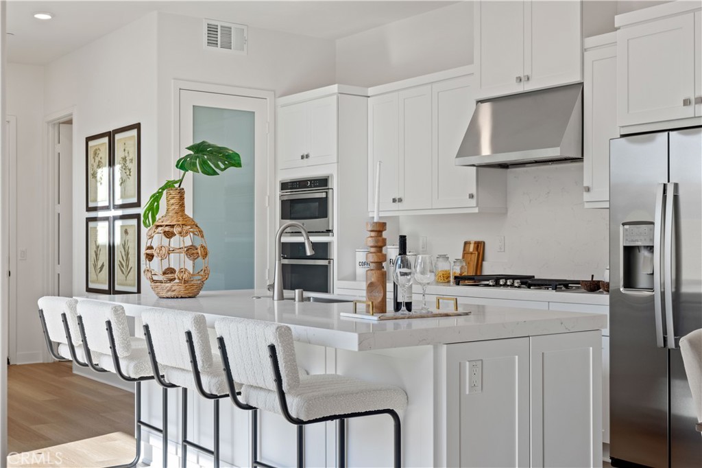 307 Baluster Irvine, CA 92618 - Photo 8 of 29 a kitchen with stainless steel appliances granite countertop a kitchen island a stove and white cabinets