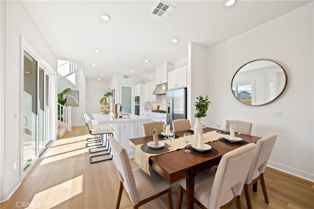 307 Baluster Irvine, CA 92618 - Photo 10 of 29 a dining room with wooden floor a glass table and chairs