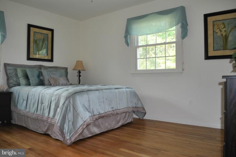19516 Olney Mill Road Olney, MD 20832 - Photo 18 of 29 a bedroom with a bed and wooden floor
