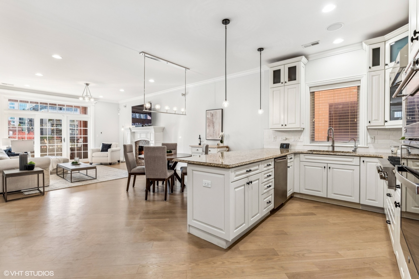 100 South Sangamon Street, Unit 3S Chicago, IL 60607 - Photo 10 of 26 a open kitchen with stainless steel appliances granite countertop a stove top oven a sink a dining table and chairs with wooden floor
