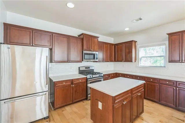 a kitchen with a stove a refrigerator and a sink