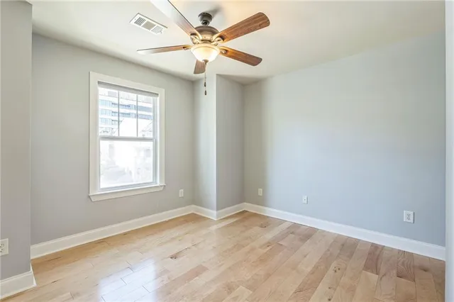 an empty room with a window and a fan