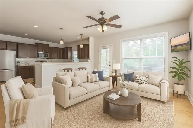 a living room with furniture kitchen and a large window