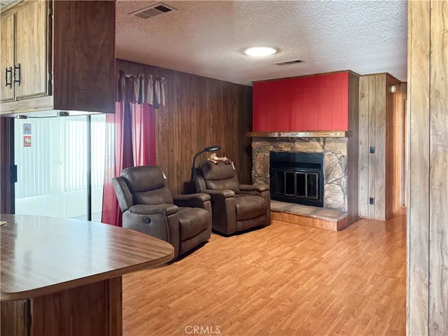 a living room with stainless steel appliances kitchen island granite countertop a stove a sink and a refrigerator